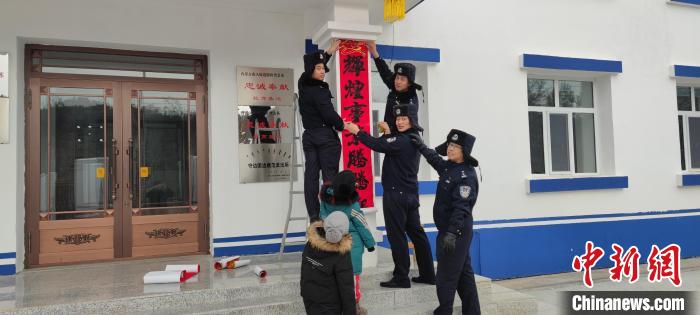 圖為恩和哈達邊境派出所民警貼對聯(lián)?！《骱凸_邊境派出所供圖